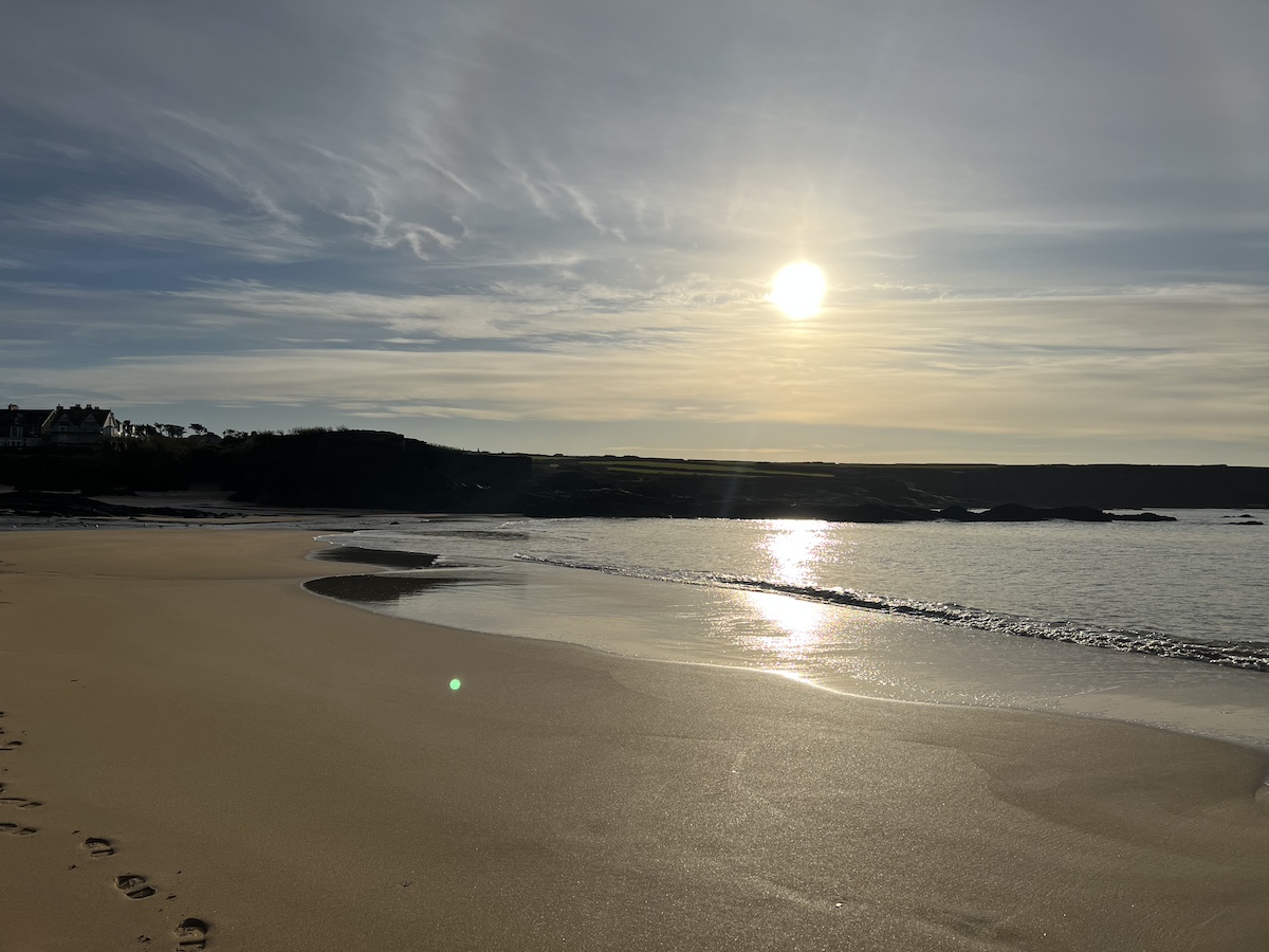 Sandy beach with sea, cliffs and sunny blue sky