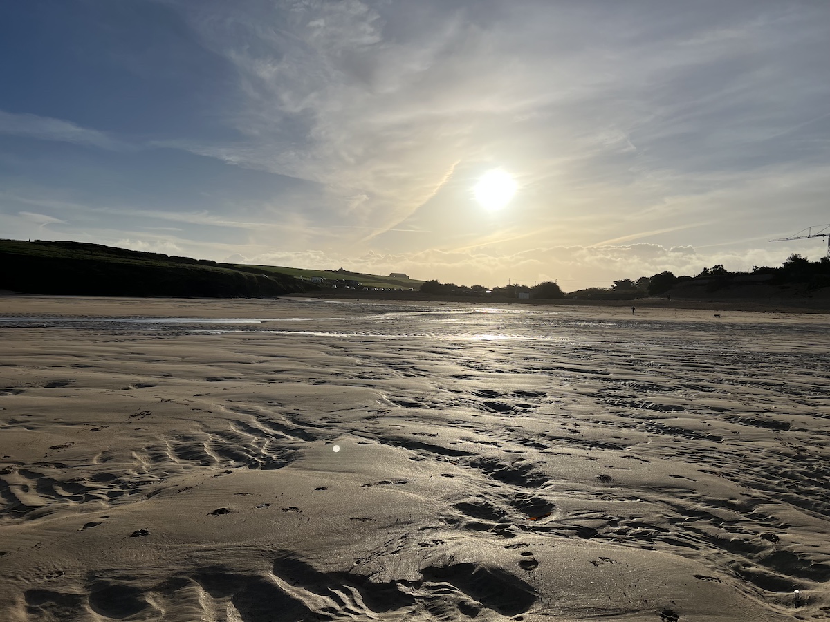 Sandy beach with sunset in the background
