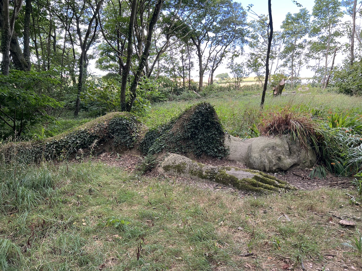 Sculpture of a sleeping figure surrounded by woodland