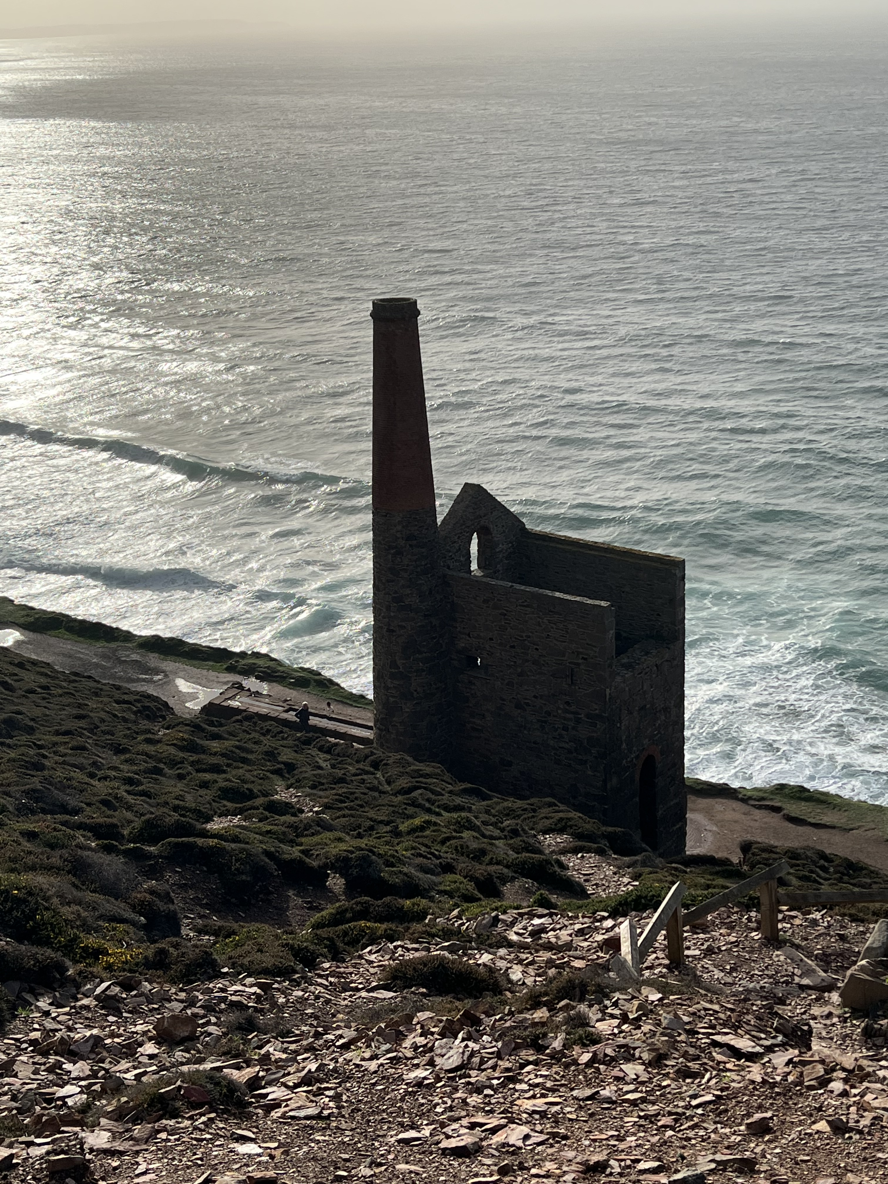 Cliff top with old mine building below on the sea shore