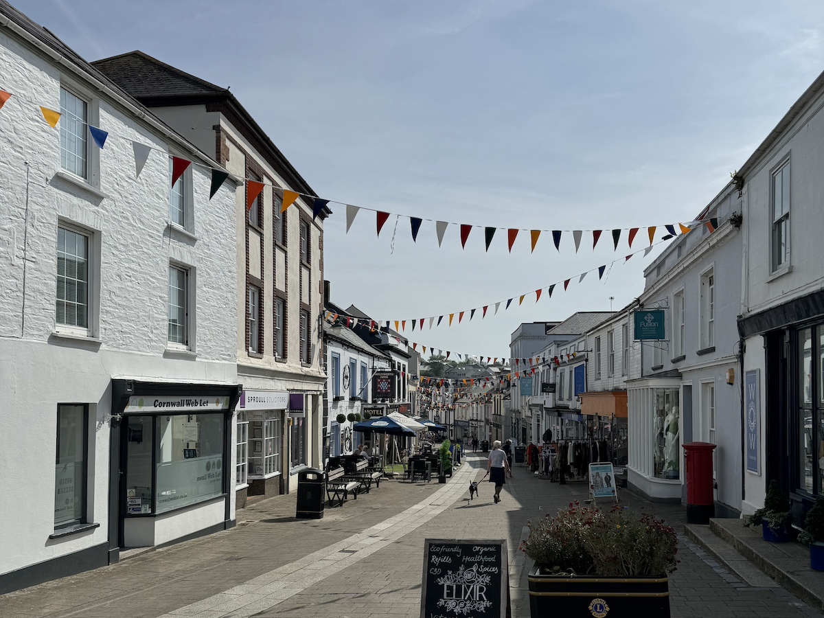 Pedestrianised shopping street with white buildings and coloured bunting